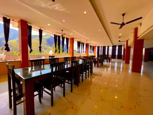 穆索里Sitara Hotel & Resort, ! Most Awarded Property in Mussoorie的一间带长桌和椅子的用餐室