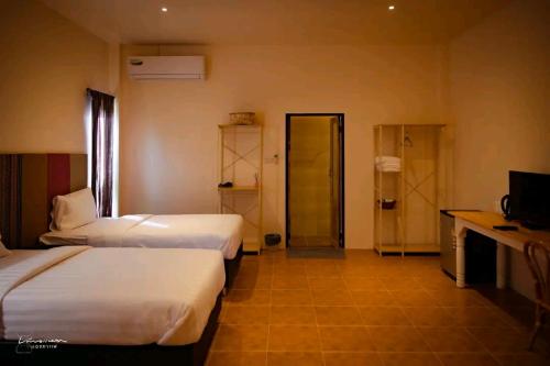 Ban Pa Muang (1)กมุทมาศ สวรรคโลก的酒店客房设有两张床和电视。