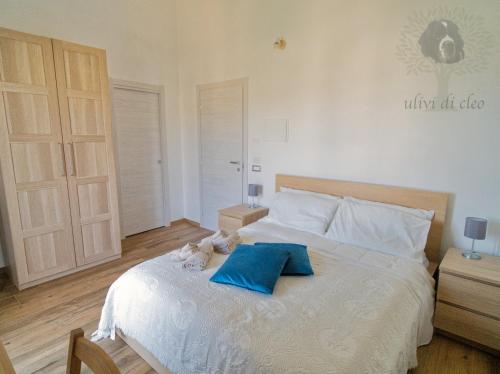 雷阿尔蒙特Ulivi di Cleo的一间卧室配有一张带两个蓝色枕头的床