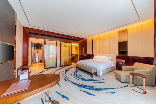 惠州Ramada By Wyndham Huizhou South的一间卧室设有一张床和一间客厅。