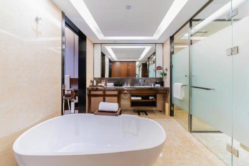 惠州Ramada By Wyndham Huizhou South的浴室配有白色浴缸和水槽