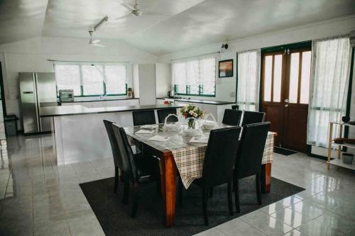 阿皮亚Heavenly Home的厨房配有带黑色椅子的餐桌
