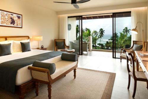 坦加拉Anantara Peace Haven Tangalle Resort的一间卧室配有一张床,享有海景