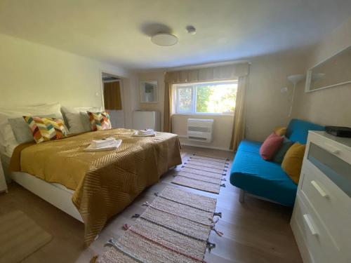 马特劳森蒂姆赖Lilakő Apartman的一间卧室配有一张床和一张蓝色的沙发