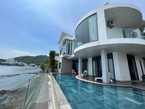 头顿Nancy Grand Vung Tau Villa的一座带游泳池的大楼,位于水边