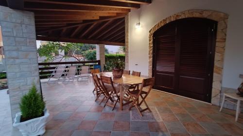 兰佩杜萨VILLA HELENA的庭院配有木桌和椅子