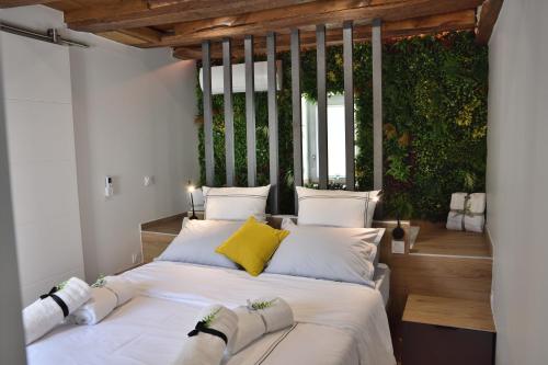 ChécyLa maisonnette relaxante de la Pommeraie的一间卧室配有带白色床单和黄色枕头的床。