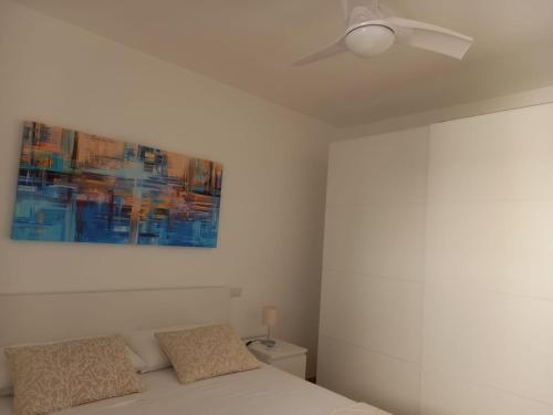 切萨雷奥港Aura Apartments - Orizzonte Turismo的一间卧室配有吊扇和一张床