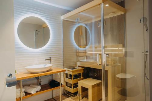 斯克拉斯卡波伦巴Platinum Adults的一间带水槽和玻璃淋浴的浴室