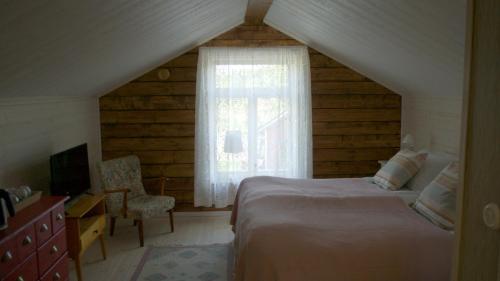 BrändöBrändö Bike and Bed的一间卧室设有一张床、一个窗口和一把椅子