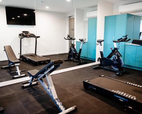 阿德莱德Peninsula Hotel Motel的健身房,室内配有几辆健身自行车
