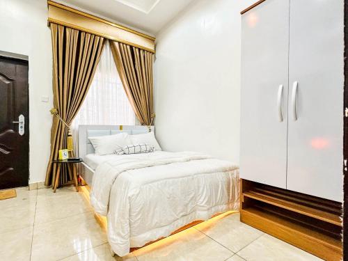 阿布贾Cozy Apartment - Hideaway with 5G WiFi的卧室配有白色的床和橱柜。