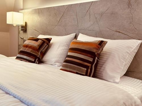 特里尔MEA HOTEL TRIER的床上配有白色枕头和条纹枕头
