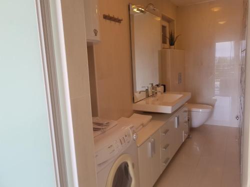 赞布雷提亚Apartments Fontana Zambratija的白色的浴室设有洗衣机和水槽。