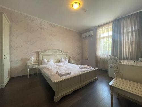 拜勒乌努麦Pensiunea 1 Mai的卧室配有白色的床和浴缸