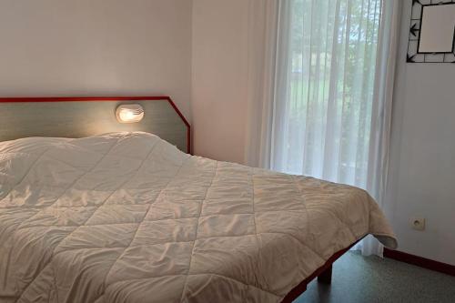 SouraïdeAdour Piscine Vue Montagnes的卧室配有一张带白色棉被的床和窗户。
