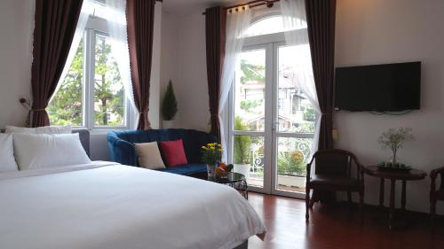 大叻FLORA HOME DALAT的一间卧室设有一张床和一个大窗户