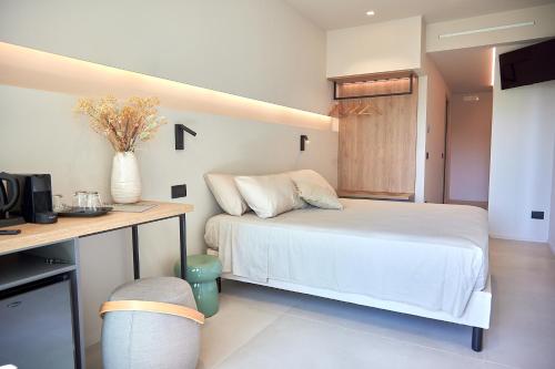 滨海波利尼亚诺White Coast的一间卧室配有一张床和一张书桌及电视