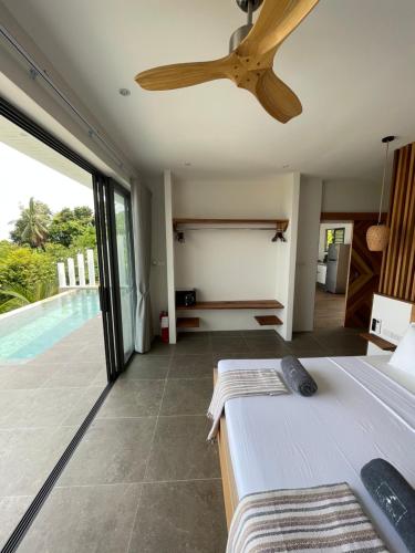 沙拉海滩LOLISEA Luxe view villas的一间带吊扇的卧室和一个游泳池