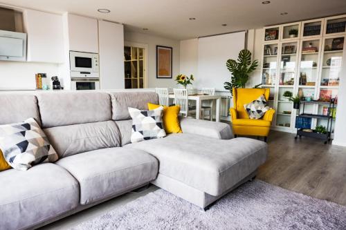 希洪Lujoso ático entre 2 playas con garaje的客厅配有灰色的沙发和黄色的椅子
