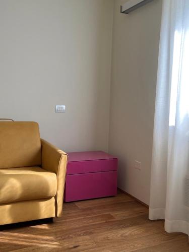 乌尔比诺Urbino Apartment - Urban Retreat的客厅配有沙发和粉红色的搁脚凳