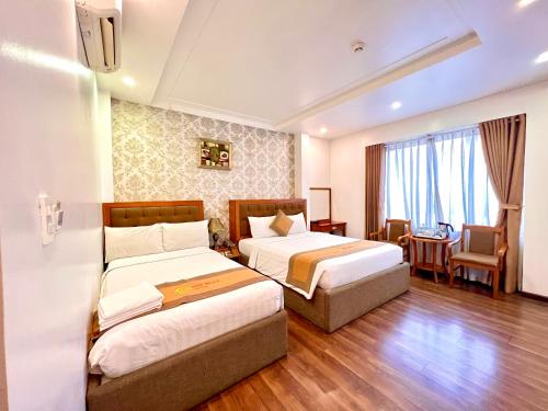 胡志明市New Space Hotel Airport的酒店客房配有两张床和一张书桌