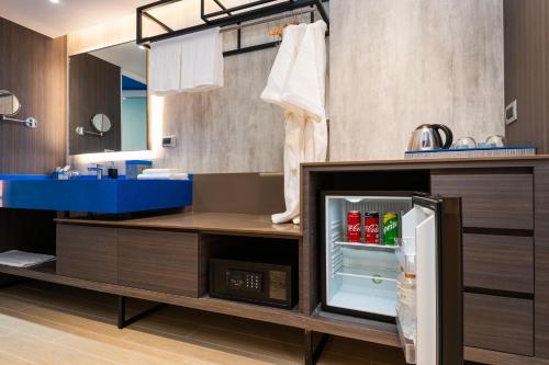 曼谷Maitria Hotel Rama 9 Bangkok - A Chatrium Collection的厨房配有带饮品的开放式冰箱
