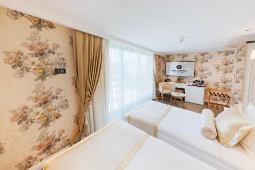 伊斯坦布尔Hallmark Hotel & SPA Istanbul的酒店客房配有两张床和一张书桌