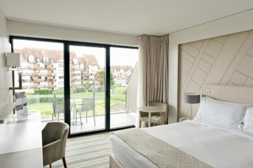 卡布尔Thalazur Cabourg - Hôtel & Spa的酒店客房设有一张床和一个大窗户