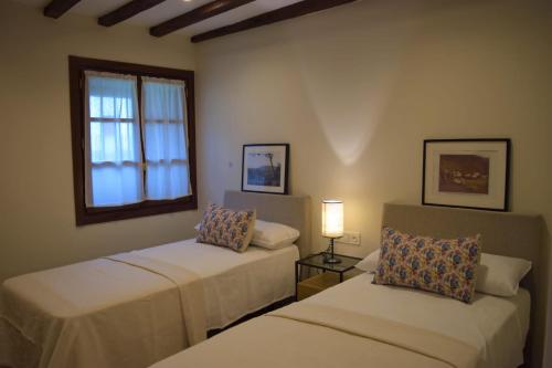 莱萨卡Peritxenea Landa Apartamentuak的客房设有两张床和窗户。