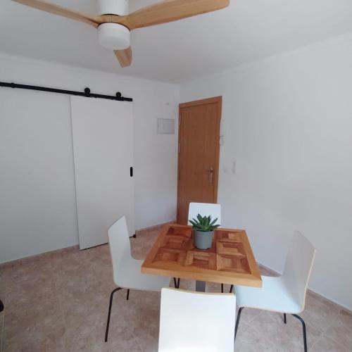 巴尔巴特#SienteELSUR的一间带木桌和白色椅子的用餐室