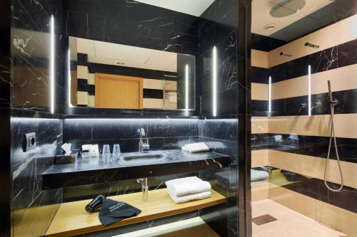 梅斯特广场酒店的黑色浴室设有水槽和淋浴