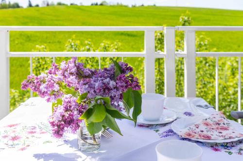 沃伦伯格Haus Seeblick Wohnung 16的白色的桌子上装有紫色花瓶