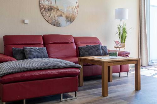 沃伦伯格Haus Seeblick Wohnung 16的客厅配有红色的沙发和桌子