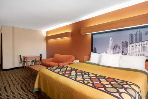 哥伦布哥伦布西速8酒店的酒店客房带一张大床和一把椅子