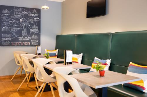 鲁汶宜必思勒芬中心酒店的用餐室配有桌椅和黑板