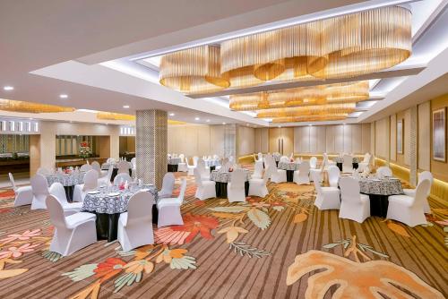 贾姆穆Country Inn & Suites By Radisson Jammu的宴会厅配有白色的桌子和白色的椅子
