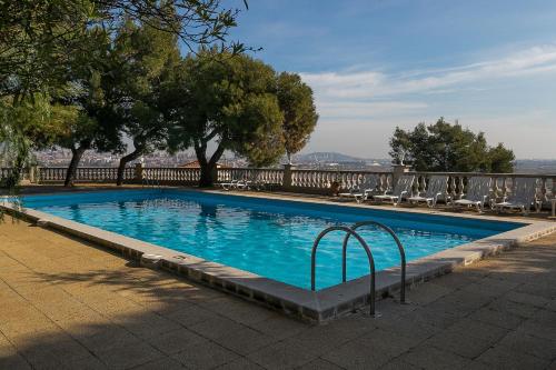 圣博伊德约布雷格城堡酒店的一个带椅子和树木的游泳池以及围栏