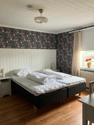 克里斯蒂娜港Karaby Gård, Country Living的一间卧室配有一张带花卉壁纸的大床
