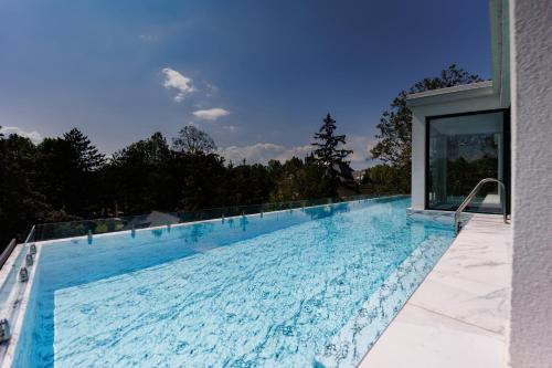 希欧福克Villa Bauhaus Wellness Apart-Hotel的蓝色海水大型游泳池