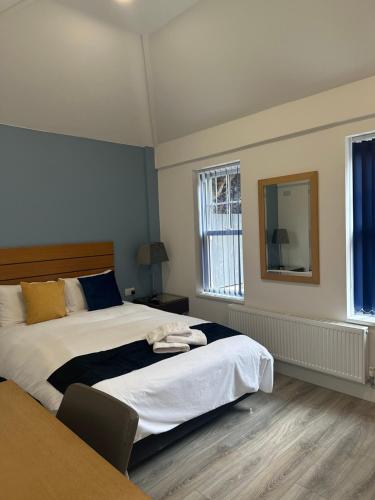 赫尔Newland Park Bungalow Near Hull Uni Free Parking Free Wi-Fi的一间卧室配有一张大床和镜子