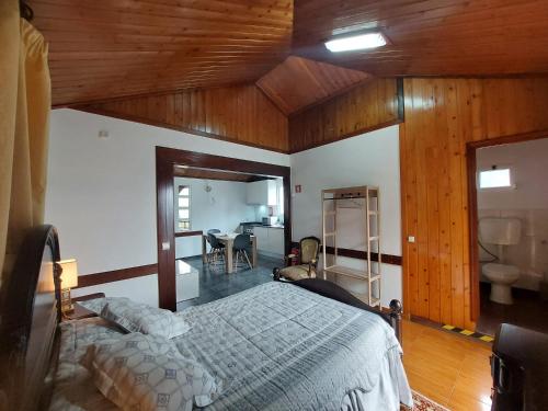 Faial3A Botanical Dimensions Nature Terraces BBQ的一间带一张床的卧室,位于带木制天花板的房间内