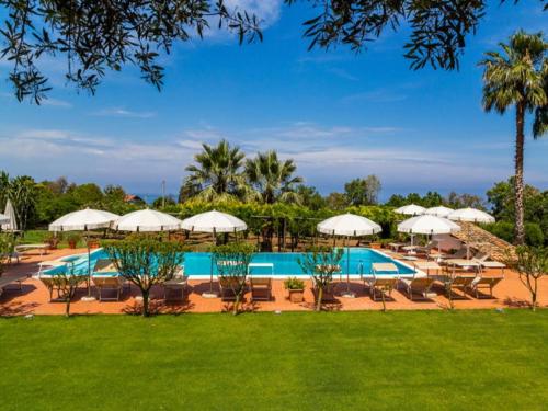里卡迪Enticing Villa in Ricadi with Shared Swimming Pool的一个带游泳池、椅子和遮阳伞的度假村
