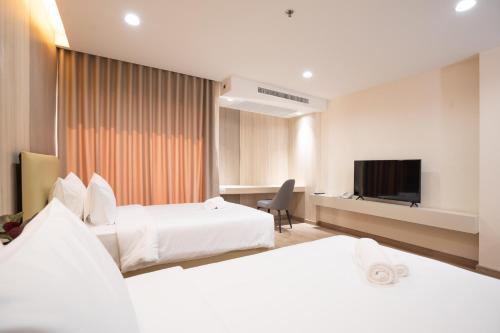 Ban Khlong ThewaOriole Residence - Suvarnabhumi的酒店客房设有两张床和一台平面电视。