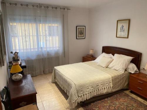 卡内·德·玛尔Big & cozy beach canet de Mar的一间卧室配有一张床、一张桌子和一个窗户。