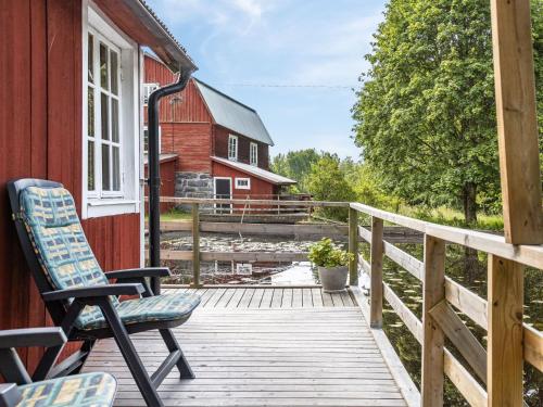 TingsrydHoliday Home Tingsmåla by Interhome的一个带椅子和红色谷仓的甲板