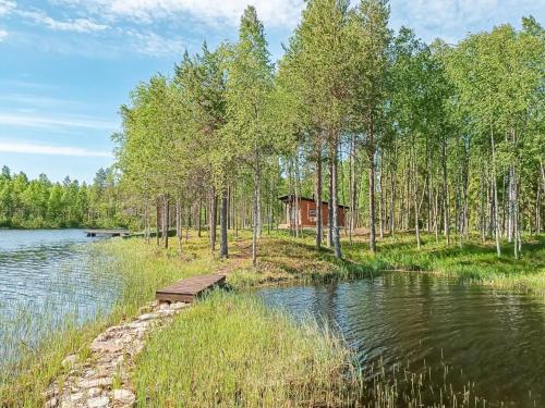 RaanujärviHoliday Home Jolmalompolo by Interhome的湖畔树林中的小屋