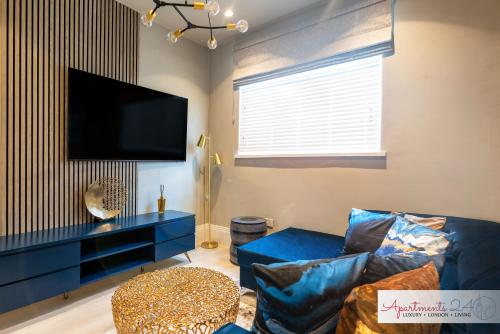 豪士罗Beautiful Apartment In London的客厅配有蓝色的沙发和平面电视。