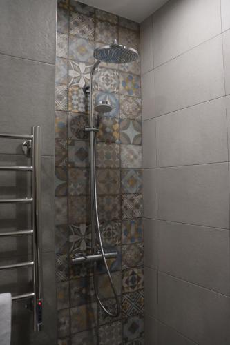 埃里温Orion ApartHotel的带淋浴的浴室(带瓷砖墙)