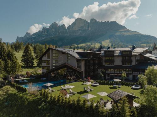 卡雷扎湖Hotel Alpenrose的一座拥有大建筑和山的度假胜地